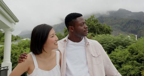 Interracial Couple Embracing Outdoors in Scenic Nature Setting