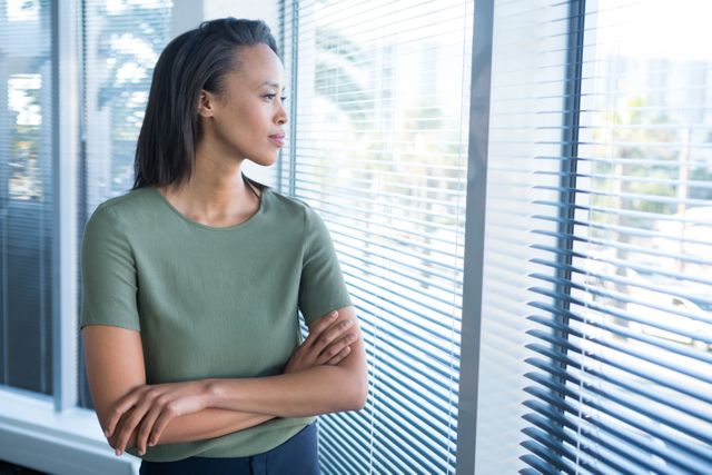 Beautiful female executives looking through window in office