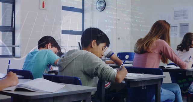 Image of multiracial students writing exam in classroom over globe and trading board. Digital composite, multiple exposure, globalization, investment, education and technology concept.