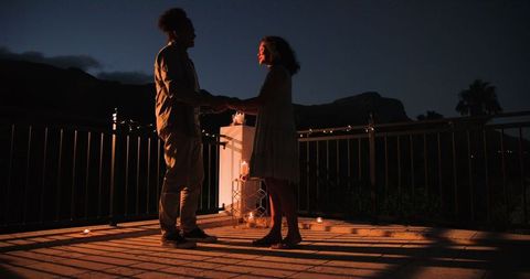 Romantic nighttime proposal illuminated by candlelight