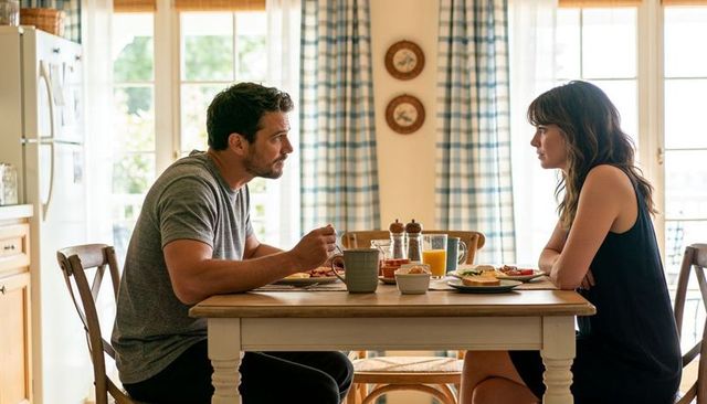 Couple having serious breakfast conversation at sunlit kitchen table with orange juice