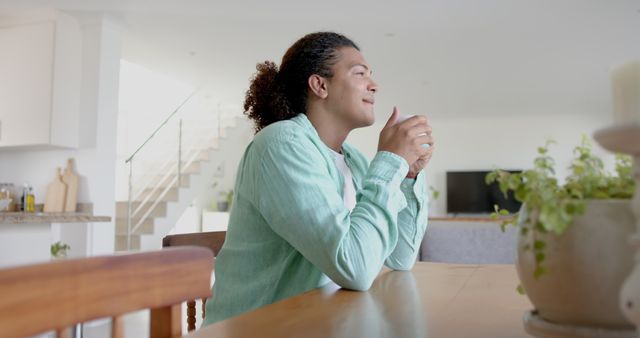 Relaxed Man Sitting at Kitchen Table Holding Cup - Download Free Stock Images Pikwizard.com