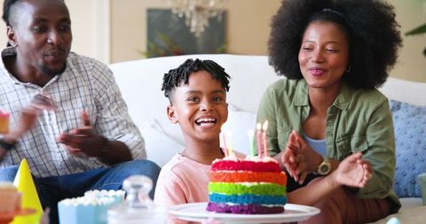 Family Celebrating Birthday at Home with Colorful Cake