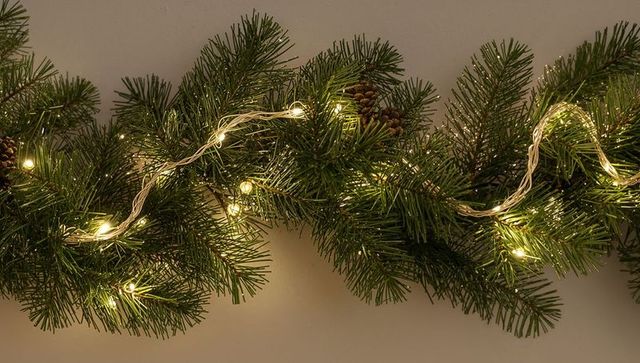 Warm pine garland with twinkling led lights and pine cones for holiday mantel door decor