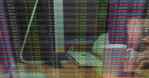 Dual-screen trading workstation showing real-time market data on desktop and laptop