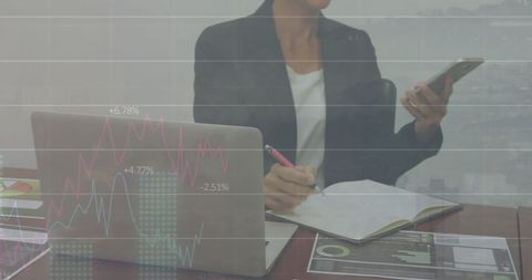 Businesswoman Analyzing Data with Laptop and Smartphone