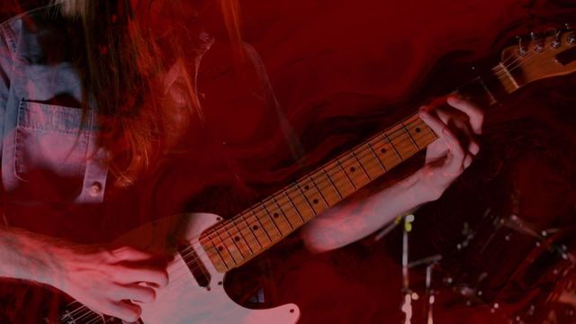 Close-up video showing guitarist's hands playing an electric guitar with swirling red lighting effects in the background. Useful for music event promotions, rock concerts, band posters, or artistic backgrounds with a musical theme.