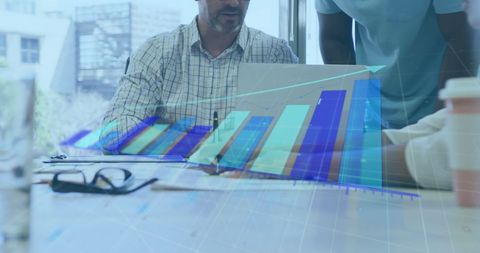 Team Analyzing Data Visualizations on Laptop in Office Environment