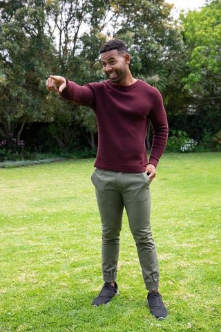 Smiling Man Gesturing on Lawn in Casual Attire