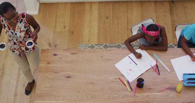 Mother Bringing Drinks While Children Color at Wooden Table - Download Free Stock Images Pikwizard.com