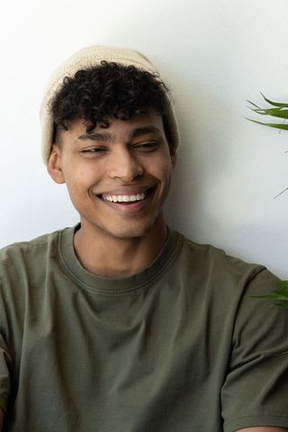 Smiling african american man wearing beige beanie and olive tee casual relaxed portrait