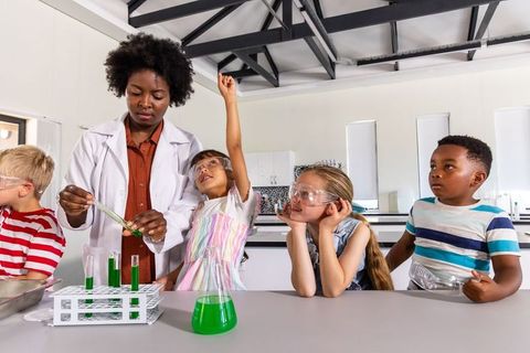 African american teacher leading hands-on chemistry with curious young students