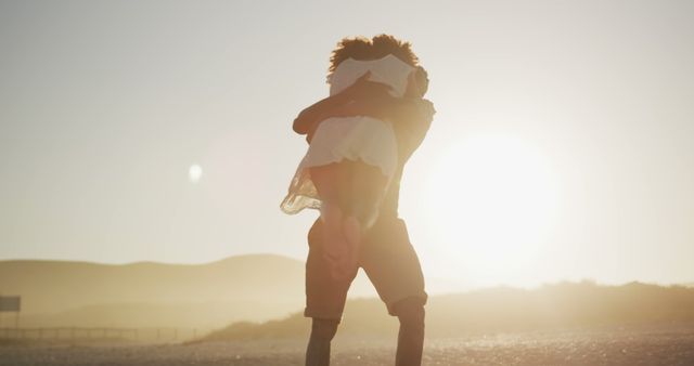 Backlit romantic diverse couple embracing on beach at sunset. Summer, free time, love, romance and vacations.