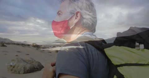 Solo hiker wearing face mask at rocky coastal sunrise