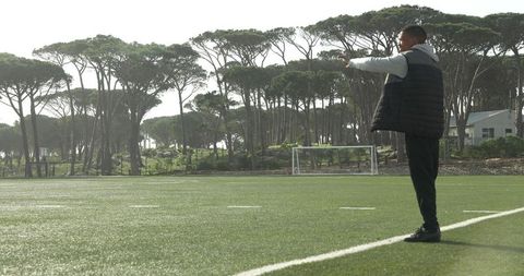 Coach Analyzing Soccer Game on Scenic Field