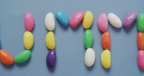 Colorful Jelly Beans Spelling 'Yummy' on Blue Surface - Download Free Stock Images Pikwizard.com