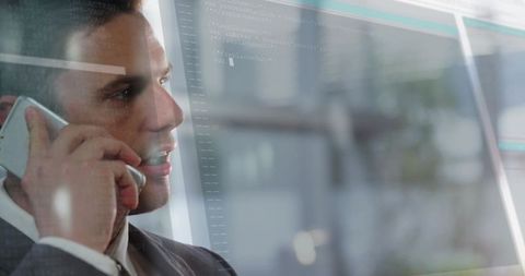 Executive Talking on Phone by Glass Window with Digital Code Overlay and Corporate Reflection