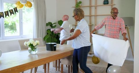 Senior Friends Celebrating at Home with Champagne