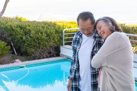 Senior Couple Embracing by Pool in Tranquil Outdoor Space