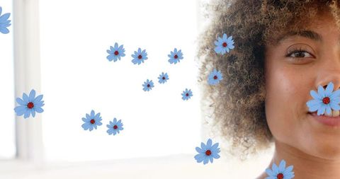 Curly woman smiling with floating blue daisies, bright minimalist backlit background, serene headsho