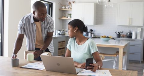 Couple Busy with Finances at Home in Modern Kitchen Interior - Download Free Stock Images Pikwizard.com