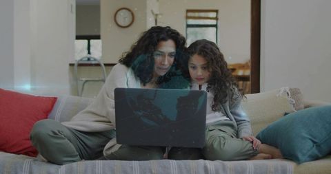 Mother and daughter sharing laptop on cozy sofa, bonding, browsing, learning and relaxing