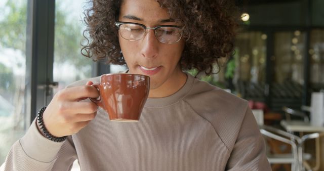 Young Man with Curly Hair Enjoying Coffee in Cafe - Download Free Stock Images Pikwizard.com