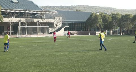 Soccer players preparing for match near modern school building