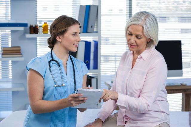 Doctor discussing prescription with senior patient in clinic. Ideal for healthcare, medical consultation, patient care, and medical advice themes. Useful for articles, brochures, and websites related to healthcare services, elderly care, and medical consultations.