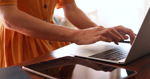 Woman Typing on Laptop at Wooden Desk with Tablet in Evening Light - Download Free Stock Images Pikwizard.com