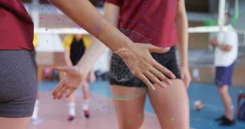 High-Fiving Volleyball Players Celebrating Teamwork on Indoor Court