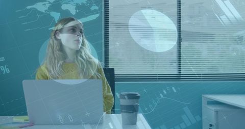 Young woman analyzing data dashboard on laptop in modern office with coffee cup