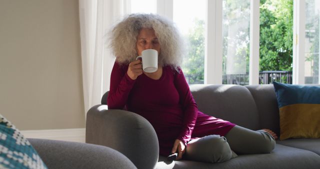 Senior Woman Relaxing On Couch While Drinking Coffee In Bright Living Room - Download Free Stock Images Pikwizard.com