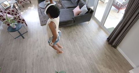 Young Woman Joyfully Dancing with Smartphone in Modern Living Room - Download Free Stock Images Pikwizard.com