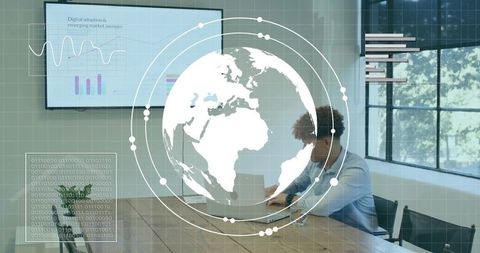 Business professional working on laptop with global data overlay and analytics dashboard