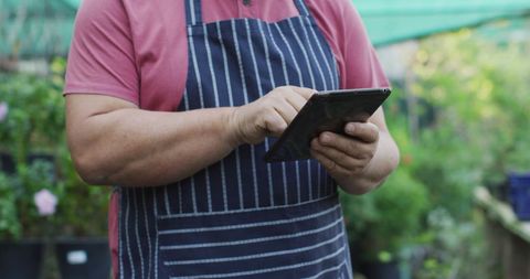 Gardener using tablet in garden center
