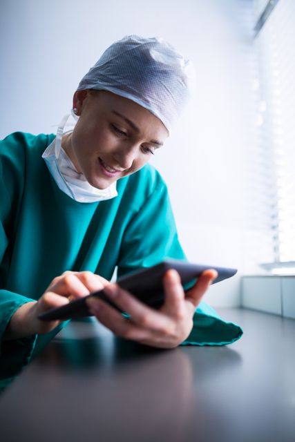 Female surgeon using digital tablet of hospital