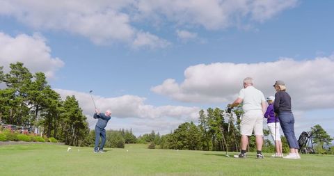 Senior Friends Enjoying Game of Golf in Scenic Setting