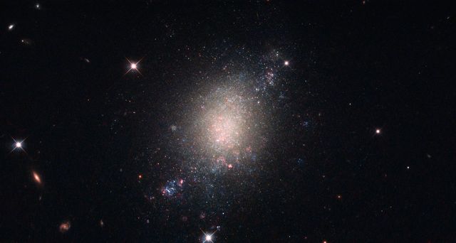 Located 30 million light-years from Earth, spiral galaxy ESO 486-21 is in the process of forming new stars. Illuminated against a backdrop of other galaxies and with visible foreground stars, this image underscores the importance of stellar evolution within galactic clusters. Perfect for educational materials, science presentations, and exploration documentaries.