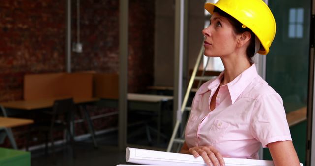 Female Architect Analyzing Construction Project with Blueprints - Download Free Stock Images Pikwizard.com