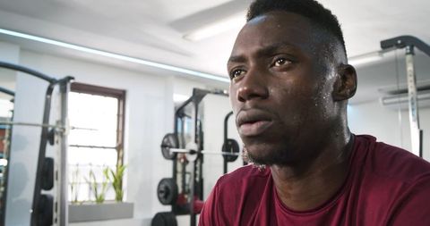 Athlete Resting Between Sets in Gym Focusing on Endurance