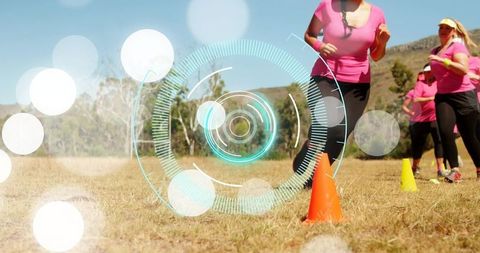 Women practicing outdoor agility drills with cones and futuristic hud overlay for fitness