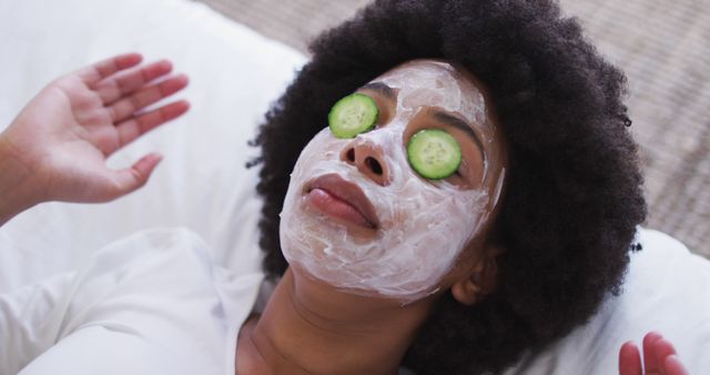 Close up of african american woman wearing face mask laying on the bed. staying at home in self isolation in quarantine lockdown