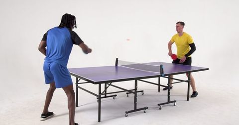 Energetic Table Tennis Match Between Friends in Modern Studio