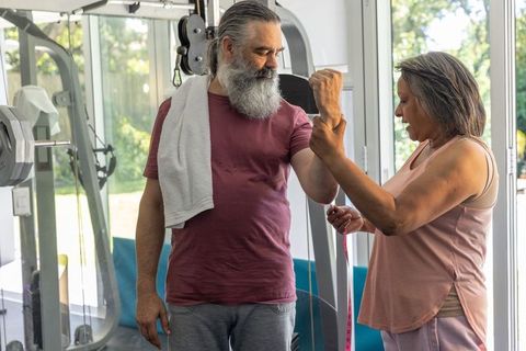 Senior couple measuring arm strength and tracking progress during home gym workout