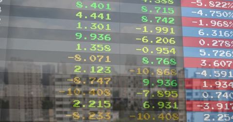 LED Stock Ticker Reflecting City Skyline on Office Glass Showing Colorful Market Numbers