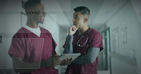 Healthcare Professionals Reviewing Patient Data in Hospital Corridor