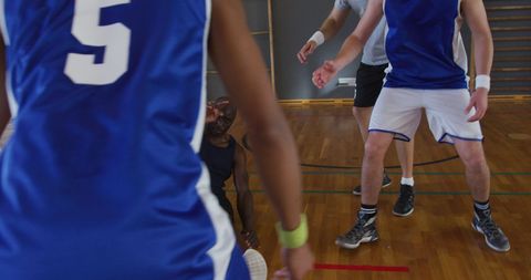 Players Assisting Teammate on Indoor Basketball Court - Download Free Stock Images Pikwizard.com