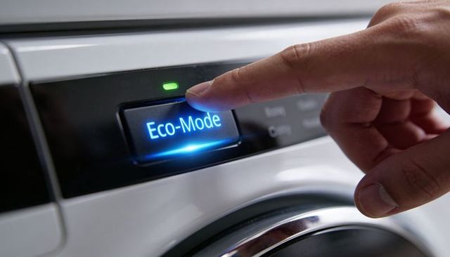 Pressing eco-mode button on front-load washer finger selecting energy saving mode