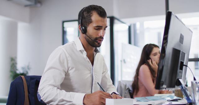 Customer service representatives working diligently with headsets in a modern office. Ideal for illustrating professional call center setups, corporate communication, business support environments, and teamwork.